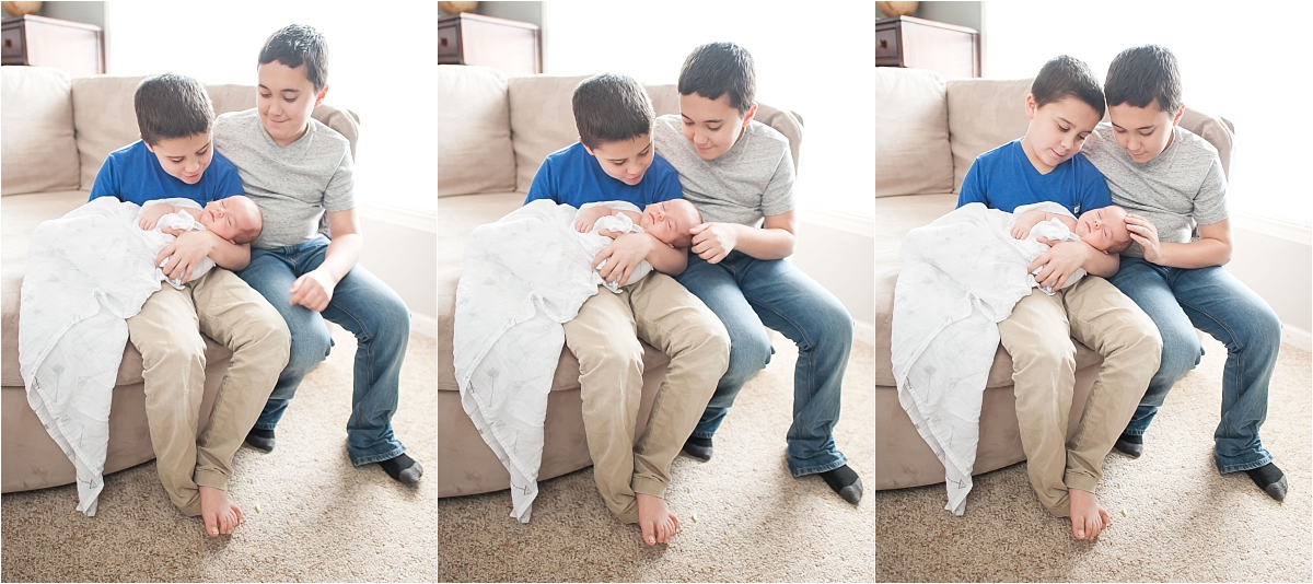 Big brothers holding newborn little brother during newborn photography session in Canton GA