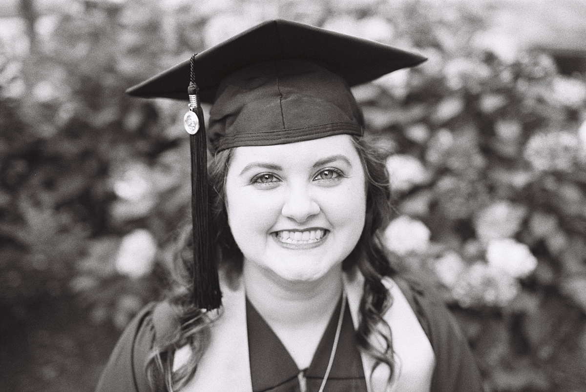 Smiling portrait of a KSU graduate on black and white film during her senior portraits by Kennesaw senior photographer Amber Watson