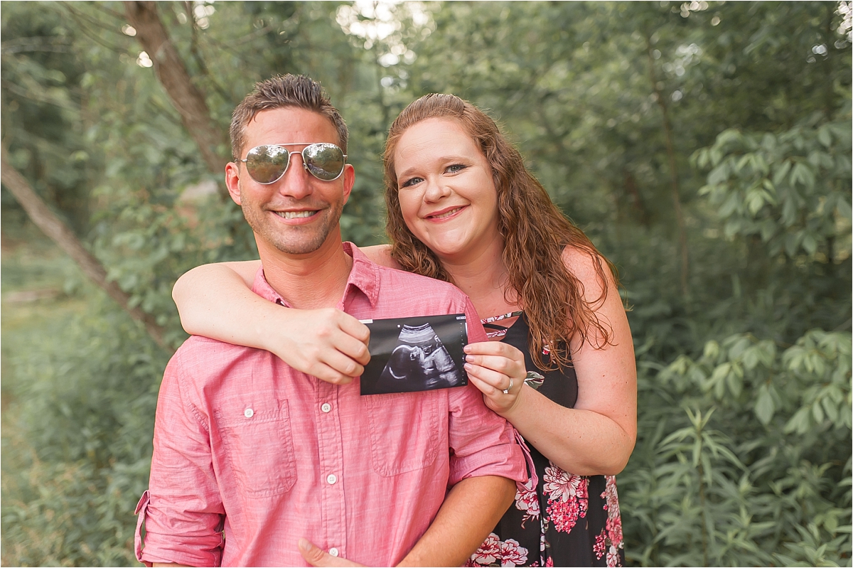 Expecting couple holding sonogram photo during their Woodstock maternity photography session by Woodstock maternity photographer Amber Watson.
