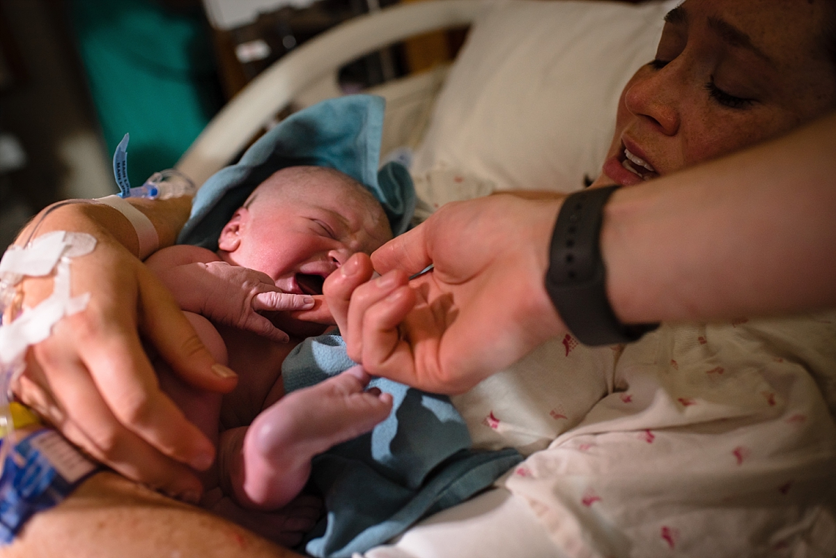 Mom holding newborn baby after birth during an Atlanta birth photography session at Kennestone Hospital in Metro Atlanta