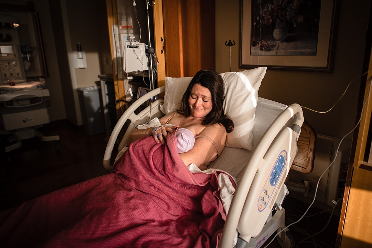 Mom nursing newborn baby after birth during an Atlanta birth photography session at Kennestone Hospital in Metro Atlanta