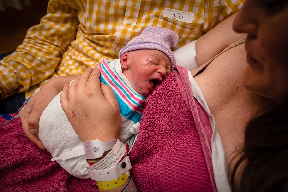 Mom holding swaddled newborn after birth during an Atlanta birth photography session at Kennestone Labor and Delivery in Metro Atlanta
