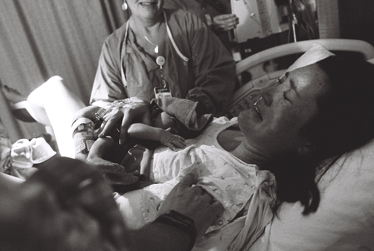 Black and white film photo of mother holding her newborn baby during an Atlanta birth photography session at Kennestone Hospital in Metro Atlanta