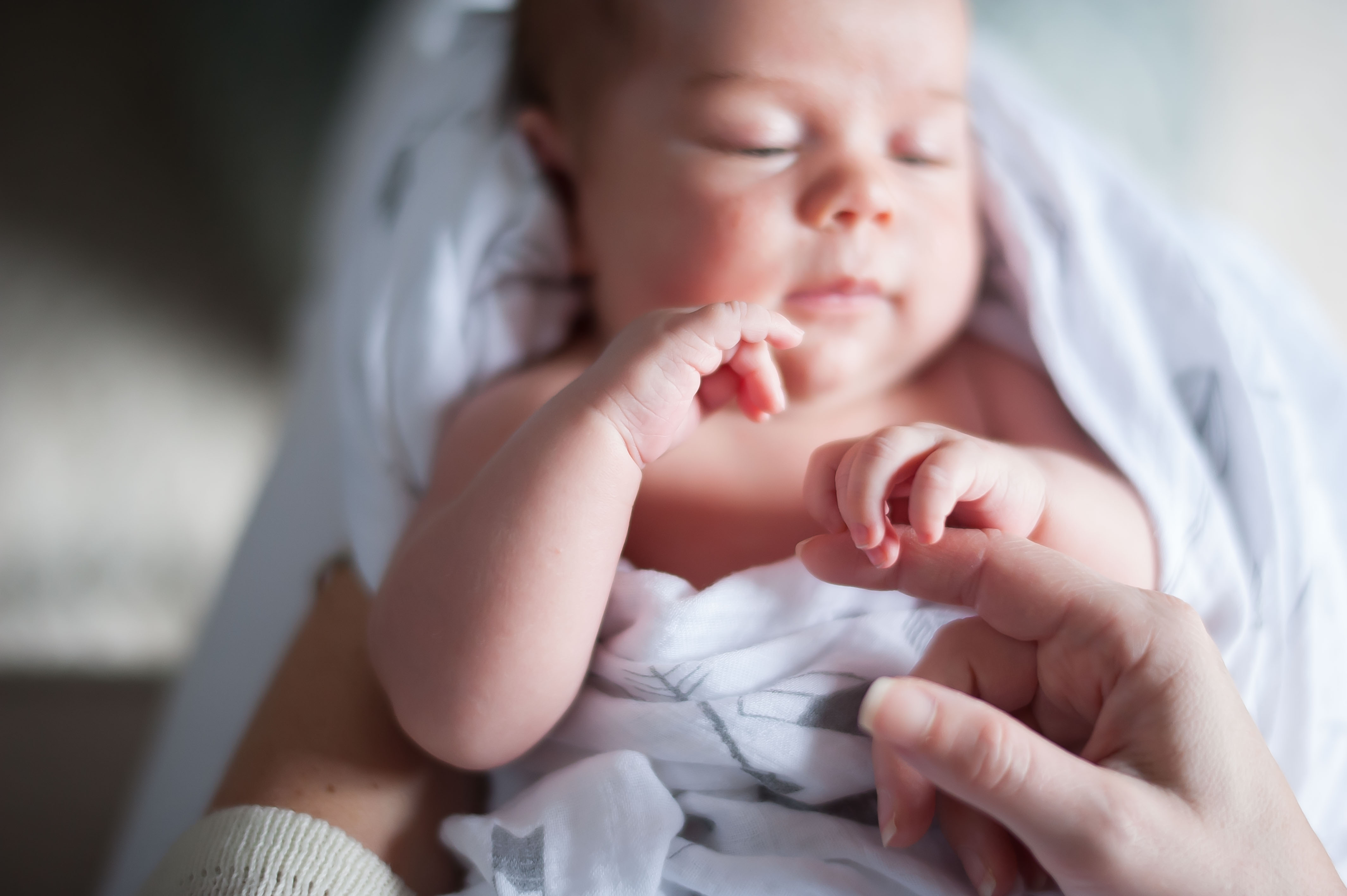 Newborn holding mom's finger