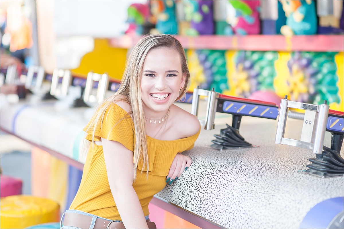 Woodstock High School senior smiling and playing games during her fair senior portraits at the North GA State Fair in Marietta, GA