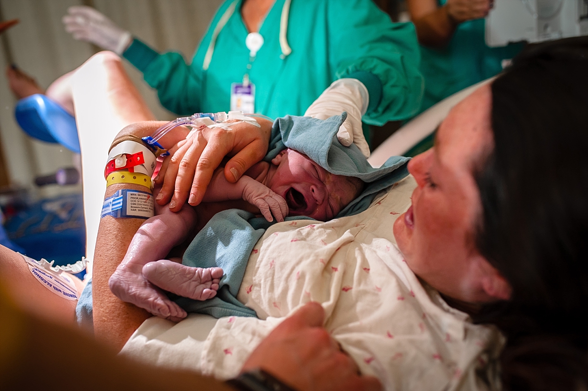 Mom holding newborn baby after birth during an Atlanta birth photography session at Kennestone Hospital in Metro Atlanta