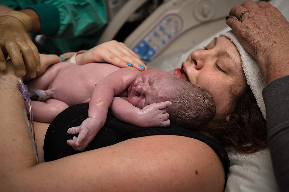 Mom holding newborn baby after birth by Atlanta birth photographer Amber Watson at Atlanta Medical Center.